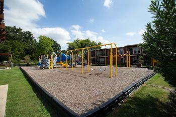 A playground with a swing set and a slide at Willow Creek Apartments, Texas, 77012